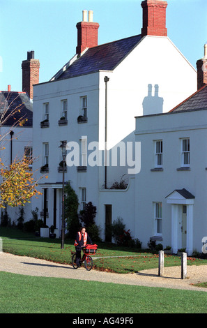 A postman delivers mail in Poundbury Village in Dorset England UK Stock Photo