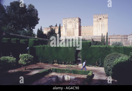 Gardener working with a hose in the magnificent Alhambra palace gardens in Granada Andalucia Spain Stock Photo