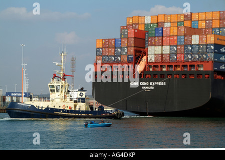 Tug Svitzer Sarah pulling Hong Kong Express a container ship operated by Hapag Lloyd from the quayside Southern England UK Stock Photo