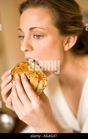 Blonde girl eating healthy sandwich Stock Photo