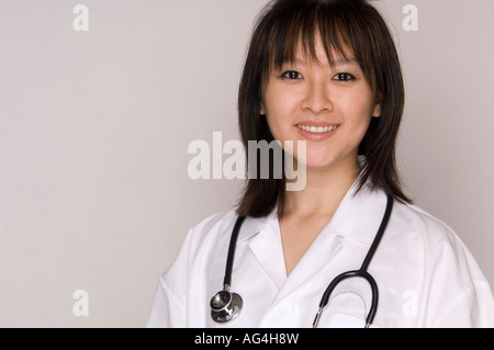 Friendly female Asian family doctor with lab coat and stethoscope. Stock Photo