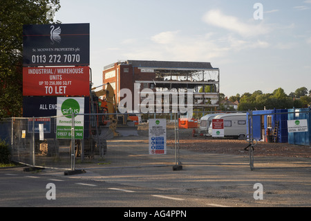 Building partially demolished (brownfield site surrounded by protective security fencing, large 'To Let' sign) - Guiseley, West Yorkshire, England UK. Stock Photo
