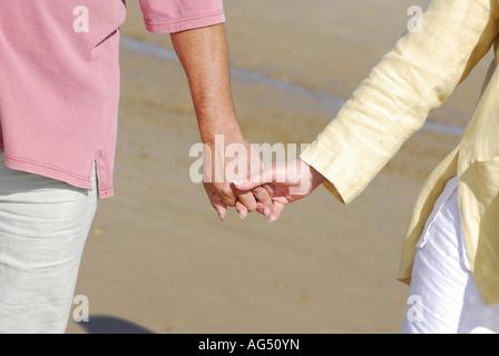 couple holding hands on beach Stock Photo