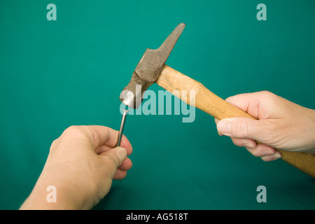 STUDIO Hitting the nail on the head with a hammer Stock Photo