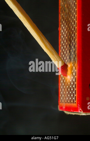 A match being struck against a matchbox Stock Photo