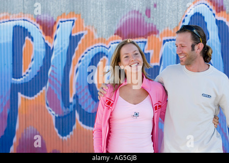 Couple talking and flirting leaning on wall Stock Photo