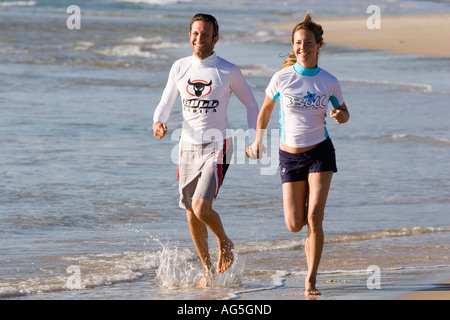 Couple in love running on the beach shore in Tarifa Cadiz Spain Stock Photo