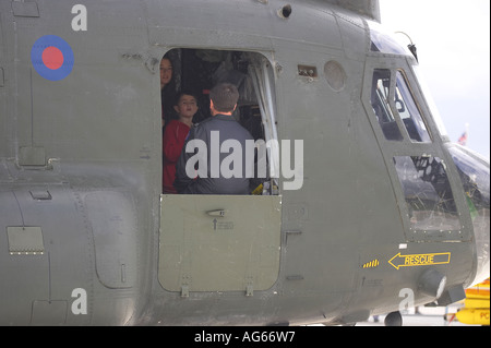 Young boy looking round the Chinook at Shoreham by sea Royal Air Forces Association Charity Airshow Stock Photo