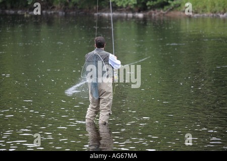 Fly Fisherman in waders, carrying landing net,  riverside wading in the River Spey, Speyside, Castle Grant beat, Scottish Highlands, Scotland uk Stock Photo