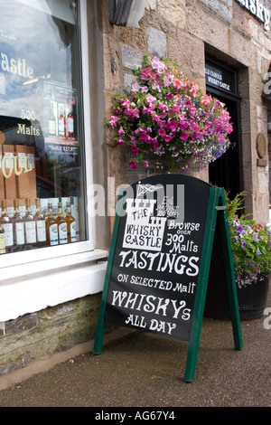 Whisky Castle advertisement, Finest malt whiskies, Scottish blends retail whisky bottle traditional built stone tourist shop in Tomintoul Scotland UK Stock Photo