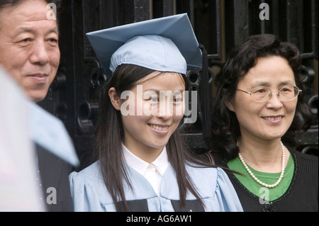 Female Asian Class Day graduate smiles and poses for photograph with parents at Columbia College in New York City USA May 2006 Stock Photo