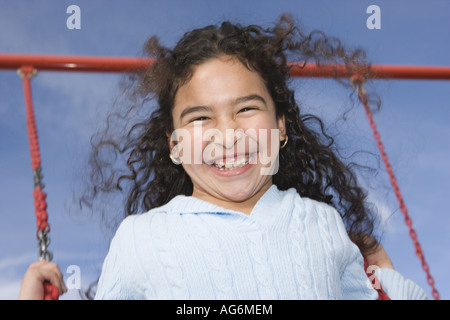 girl making ecstatic face while swinging hight into the air Stock Photo
