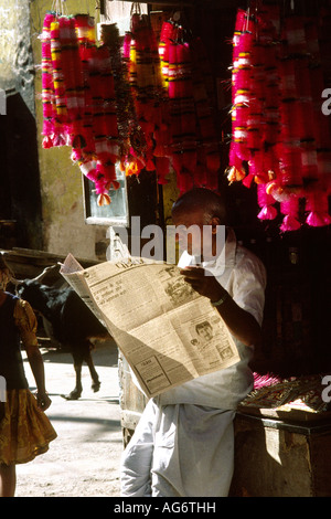 India Rajasthan Barmer garland stall owner reading his newspaper Stock Photo