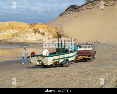 A dory part of the Pacific City fishing fleet launches from the beach in front of Haystack Rock in Pacific City Stock Photo