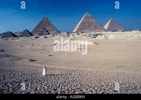Egypt Pyramids of Giza Egyptian man dressed in white robes as size perspective Stock Photo