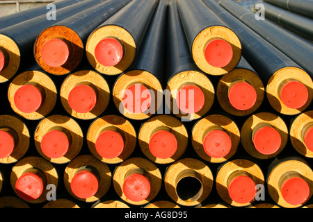 Inventory pile of Insulated pipes used for delivering heated water from district heating power plant to households , Finland Stock Photo