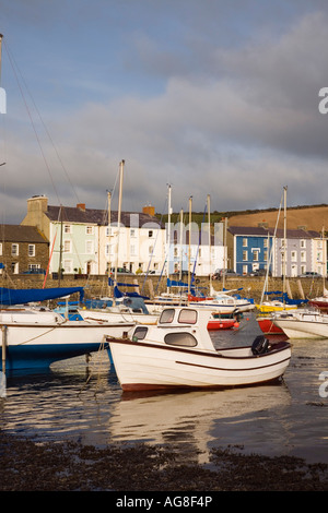 View across muddy harbour at low tide with boats moored and quayside houses in seaside town Aberaeron Ceredigion Mid Wales UK Stock Photo