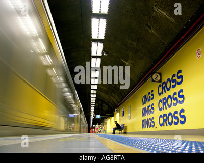 Arriving train and sitting passenger in the Kings Cross Metro Stration in the quarter Kings cross in Sydney, New South Wales Stock Photo