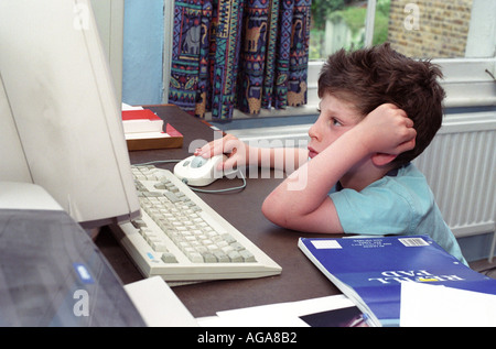 A 6 year old boy using a PC computer at home. Stock Photo