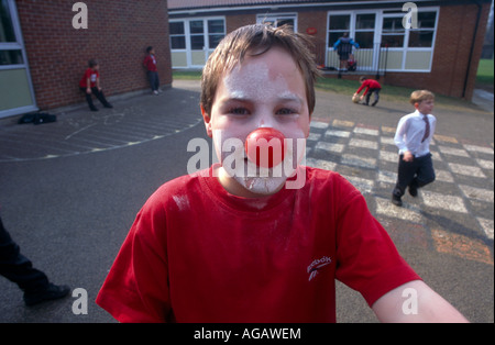 Boy Wearing Red Nose For Comic Relief In School Playground Stock Photo