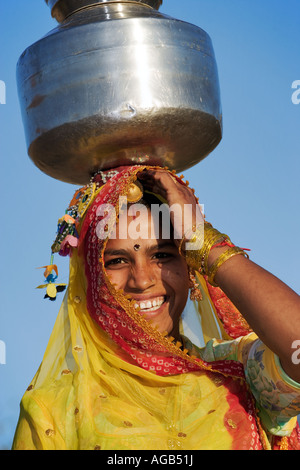 Woman carrying water in the traditional way from a well outside of Pushkar India Model released Stock Photo