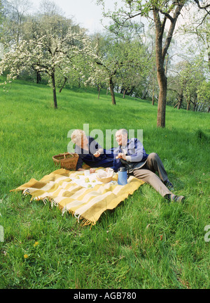 Elderly couple having picnic under blossoms in Petrin Park in Prague Stock Photo