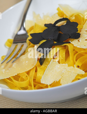 A bowl of tagliatelle with shaved black truffles and shaved Parmesan cheese. Stock Photo