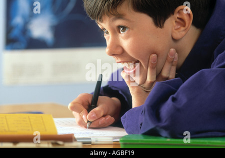 Close up of boy doing homework head on hand Stock Photo