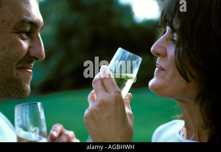 Taupo a romantic couple drinking champagne in the gardens of the Huka Lodge luxury accommodation Stock Photo