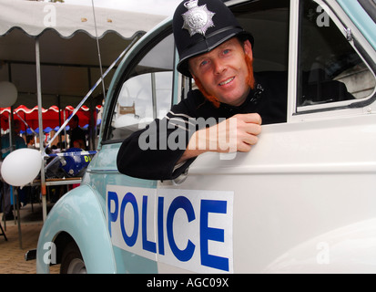 Police Officer in retrospective uniform and patrol car at Kingston Carnival 2007, Kingston, Surrey, UK. Stock Photo