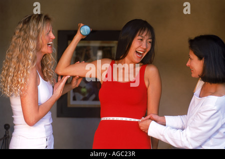Three women of ethnic mix sharing health and fitness ideas in bedroom Stock Photo