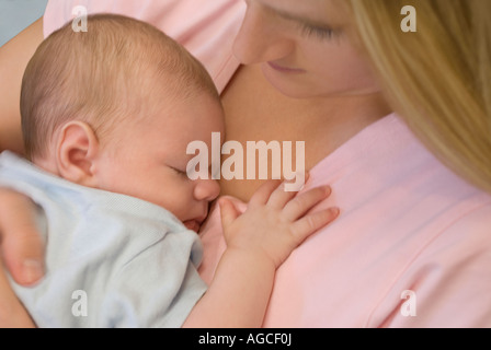 Close up of infant sleeping on mother's chest Stock Photo