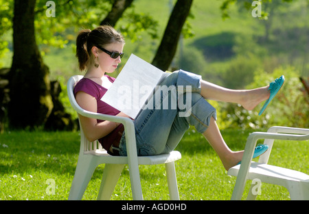 Teenage student doing her exam revision / studying outside / in the garden Stock Photo