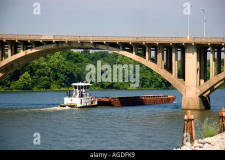 Tug boat and river barge pass under a bridge over the Arkansas River in Little Rock, Arkansas. Stock Photo