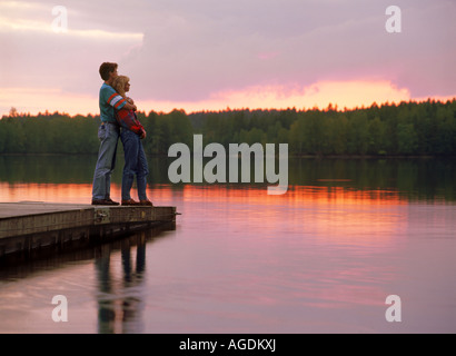 Romantic couple embrace lakeside sunset hi-res stock photography