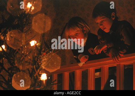 Brother and sister staring at Christmas tree Stock Photo