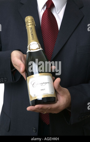 Bottle of champagne being presented by a businessman All labels have been substantially altered to avoid copyright issues Stock Photo