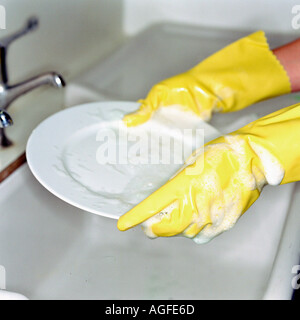 Washing up with rubber gloves Stock Photo
