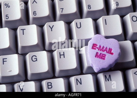 Heart shaped candy with the words e mail me on keyboard Stock Photo