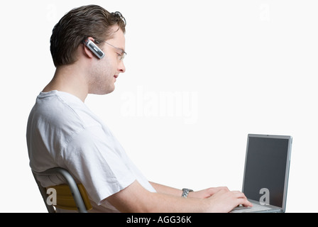 Side profile of a young man using a laptop Stock Photo