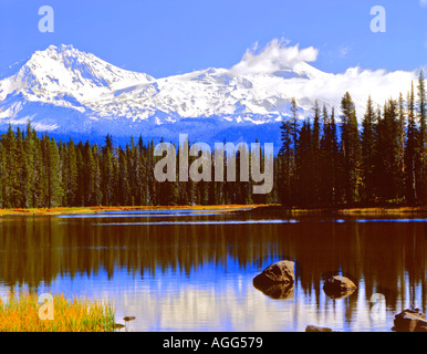 Scott Lake in the Cascade mountains of Oregon with new Autumn snow on the North and Middle Sister mountains reflected in lake Stock Photo