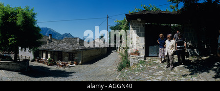 Europe Greece Epiros Vikos Aoös National Park Megalo Papingo Family emerges from traditional stone houses Stock Photo