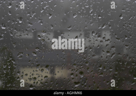 A foggy, rainy, winter's day looking out through a window with houses in background Stock Photo