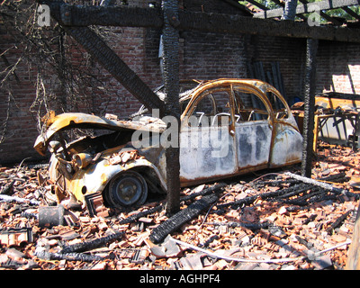 wreck of burnt out citroen 2CV in barn Stock Photo