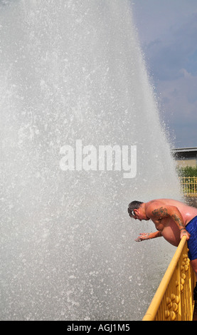 Man cooling off in fountains at Battersea Park Stock Photo