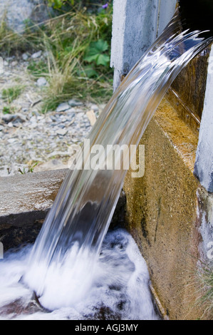 A stream emerging from a small scale HEP scheme on the side of the Aiguille rouge above Chamonix France Stock Photo