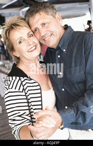 Side profile of a mature woman dancing with a senior woman in a nightclub and smiling Stock Photo
