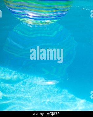 Reflection of a beach ball floating in swimming pool Stock Photo