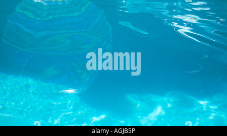 Reflection of a beach ball floating in swimming pool Stock Photo