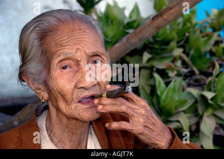 Myanmar Bagan Popa mountain park old woman smoking a cigar Stock Photo